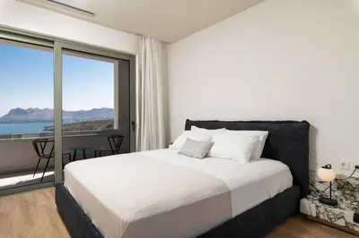 a bedroom with a bed with a view of the ocean at 2 sea view Villas as 1 by Chania Living Stories in Chania Town
