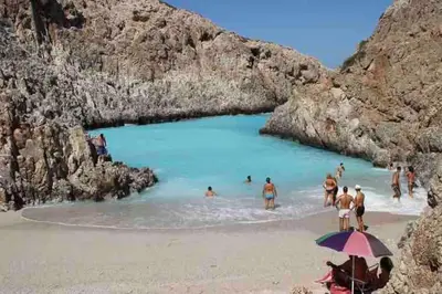 a group of people in the water at a beach at 2 sea view Villas as 1 by Chania Living Stories in Chania Town