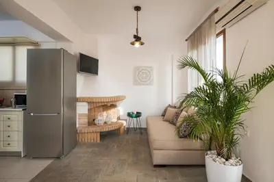 a living room with a refrigerator and a couch at Seaview Villa Ormos, Heated Pool, Sea & Sun Villas in Chorafakia