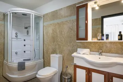 a bathroom with a toilet and a sink and a shower at Seafront Villa Shore, Sea & Sun Villas in Chorafakia