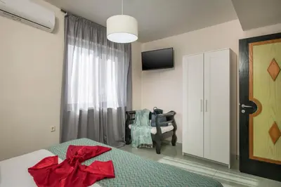 a bedroom with a bed with a red bow on it at Seafront Villa Shore, Sea & Sun Villas in Chorafakia