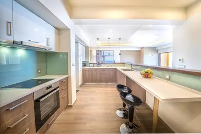 a large kitchen with wooden cabinets and a large island at Golden View Luxury Villa Platanias in Plataniás