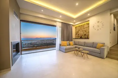a living room with a couch and a large window at Golden View Luxury Villa Platanias in Plataniás