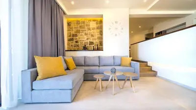 a living room with a blue couch and two tables at Golden View Luxury Villa Platanias in Plataniás