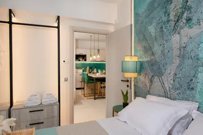 a bedroom with a bed with a blue wall at Flos Apartments in Korakiaí