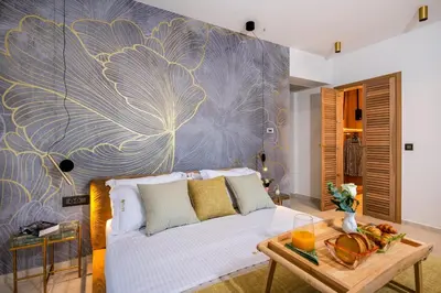 a living room with a white couch and a large flower mural at Flos Apartments in Korakiaí
