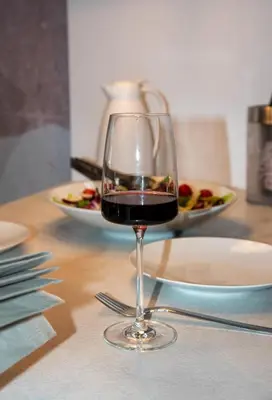 a glass of red wine sitting on a table at Flos Apartments in Korakiaí