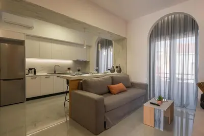 a living room with a couch and a kitchen at Amara Local Experience in Chania Town