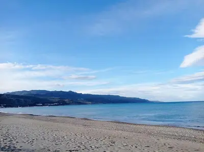 a beach with the ocean and mountains in the background at Micro_Ble vacation home in Ropanianá
