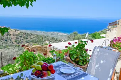 a table with a bowl of fruit on top of a hill at Traditional Stone House with Mountain & Sea Views 