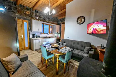 a living room with a table and a kitchen at Traditional Stone House with Mountain & Sea Views 