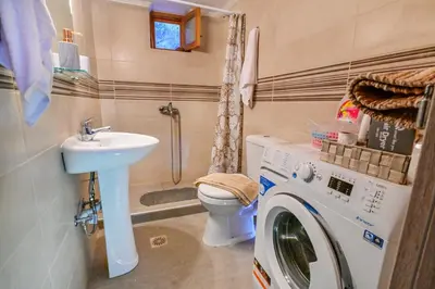 a bathroom with a washing machine and a sink at Traditional Stone House with Mountain & Sea Views 