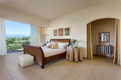 a bedroom with a bed and a large window at Villa Kapodistria in Kallithea-Voukolies