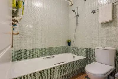 a bathroom with a white tub and a toilet at Villa Kapodistria in Kallithea-Voukolies