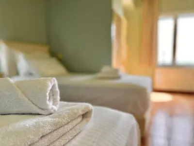 a room with two beds with white towels on them at Villa Kapodistria in Kallithea-Voukolies