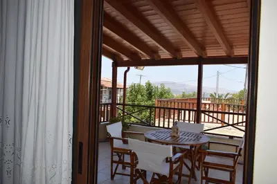 a patio with a table and chairs on a balcony at Villa Helidoni in Pondikianá