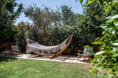 a hammock and two chairs in a garden at Villa Dimi in Kalathas