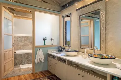 a bathroom with two sinks and two mirrors at Villa Dimi in Kalathas