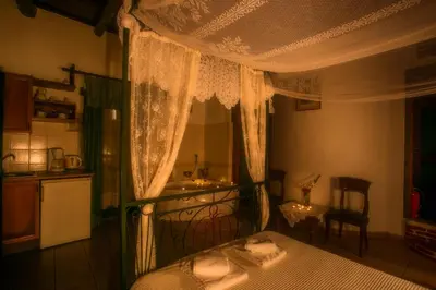 a bedroom with a canopy bed and a kitchen at IFIGENIA ROOMS BY MARIOS in Chania Town