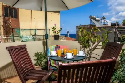 a table with cups and drinks on a balcony at IFIGENIA ROOMS BY MARIOS in Chania Town
