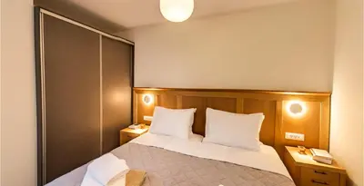 a bedroom with a bed with white pillows and two tables at Mitos Villas in Gerani Chanion