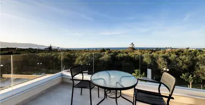 a patio with a table and chairs on a balcony at Mitos Villas in Gerani Chanion