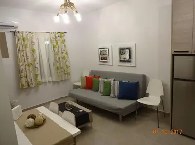 a living room with a gray couch with colorful pillows at ML in Chania Town