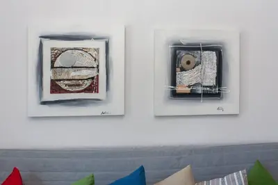 two framed pictures hanging on a white wall at ML in Chania Town