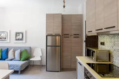 a kitchen with a refrigerator and a couch in a room at ML in Chania Town