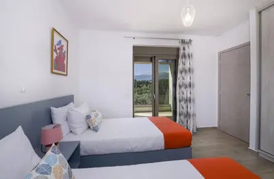 a hotel room with two beds and a balcony at Almyrida Hills Villas in Koprána