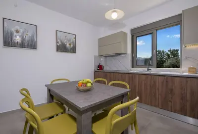 a kitchen and dining room with a table and chairs at Almyrida Hills Villas in Koprána