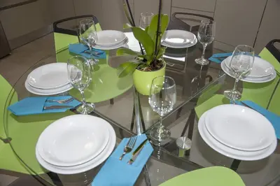 a glass table with white plates and a plant on it at Almyrida Hills Villas in Koprána