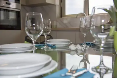 a table with wine glasses and plates on it at Almyrida Hills Villas in Koprána