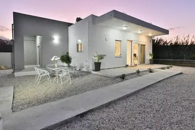 a house with a table and chairs in a yard at Magedico 150m from the beach in Kissamos
