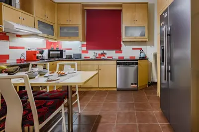 a kitchen with wooden cabinets and a table and a refrigerator at Seafalios Villa in Chania Town