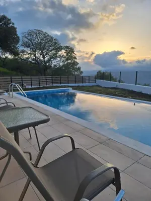 a swimming pool with a table and chairs next to it at Kandania Paradise in Kántanos
