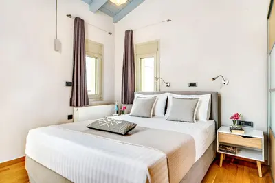 a white bedroom with a large white bed and windows at La Casa Di Fiori Stylish Holiday Home in Plataniás