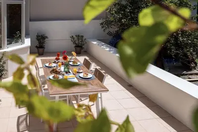 a table with food on it on a patio at La Casa Di Fiori Stylish Holiday Home in Plataniás