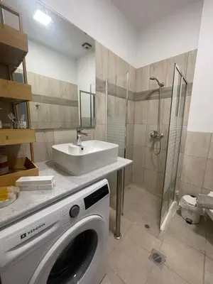 a bathroom with a washing machine and a sink at AIOLOS Chania center luxury apartment near the garden in Chania Town