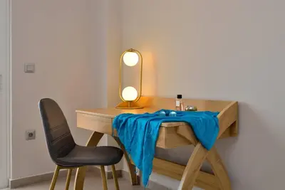 a desk with a blue blanket on it with a chair at Elma's Villa: A peaceful, family-friendly place in Daratso