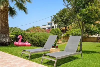 two chairs and a table and a flamingo toy in a yard at Elma's Villa: A peaceful, family-friendly place in Daratso