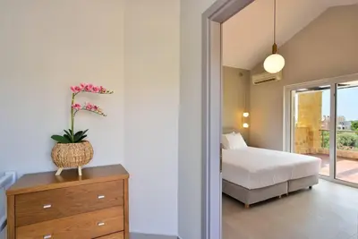 a bedroom with a bed and a dresser with a plant on it at Elma's Villa: A peaceful, family-friendly place in Daratso
