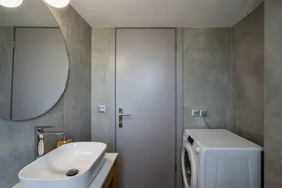 a bathroom with a washing machine and a sink at Elma's Villa: A peaceful, family-friendly place in Daratso