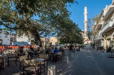 a group of people sitting at tables in a street at Splatzia old town house in Chania Town