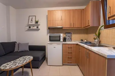 a small kitchen with a couch and a microwave at Splatzia old town house in Chania Town