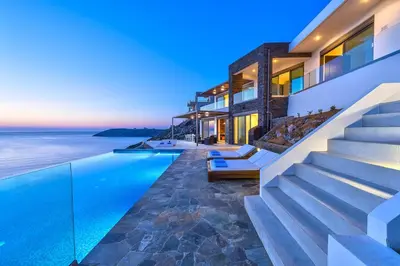 a house with a swimming pool next to the ocean at Luxury seafront design villa Kyma in Tersanas Owner listing in Tersanas