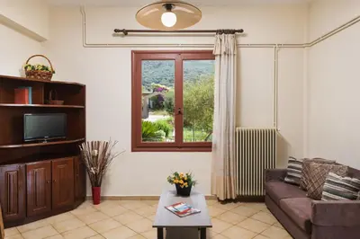 a living room with a couch and a window at Garden House with Pool, 10min to center in Nerokoúros