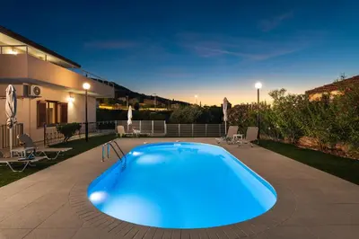 a large blue swimming pool in the backyard of a house at Garden House with Pool, 10min to center in Nerokoúros