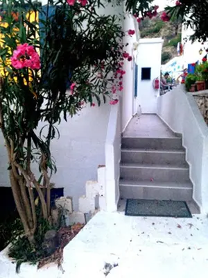 a staircase with pink flowers next to a building at Sofia Rooms in Loutro