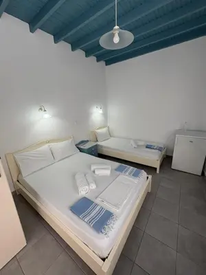 a bedroom with a large bed and two tables at Sofia Rooms in Loutro